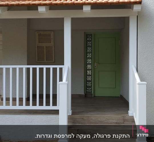 כניסה לבית עם דלת ירוקה, מדרגות עץ וריצוף אבן